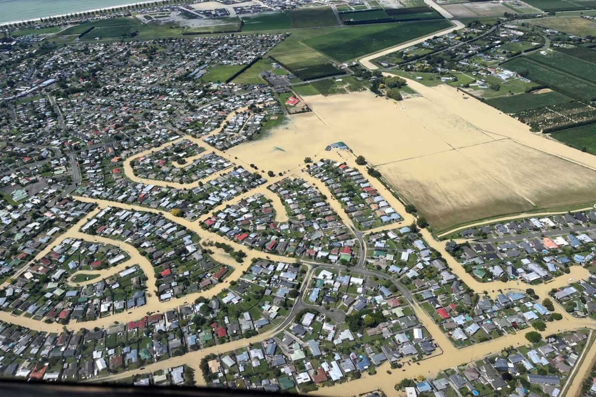 Aerial view of flooded residential area with muddy water covering streets.